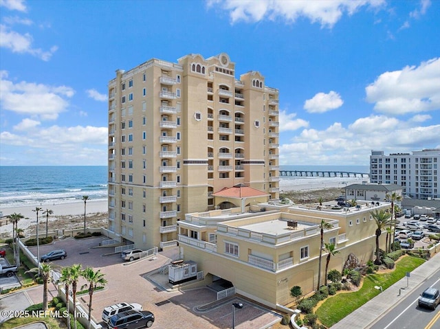 view of building exterior featuring a beach view, a water view, and central air condition unit