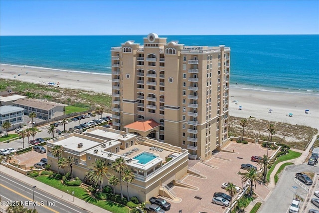 drone / aerial view featuring a beach view and a water view