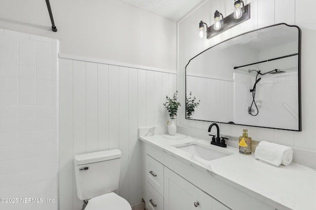 full bath with toilet, a wainscoted wall, walk in shower, and vanity