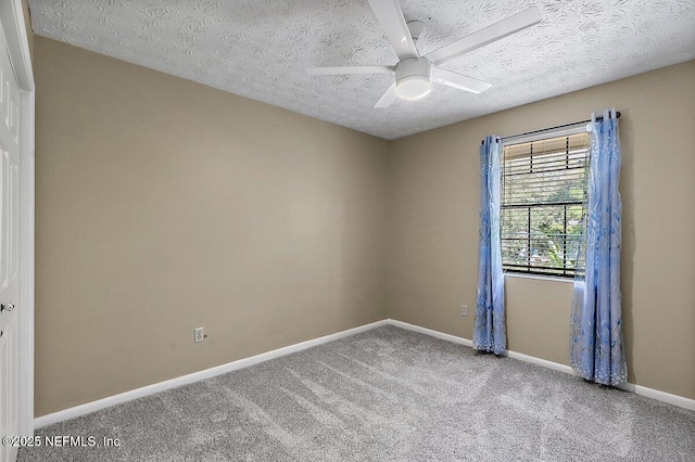 carpeted empty room featuring ceiling fan, a textured ceiling, and baseboards