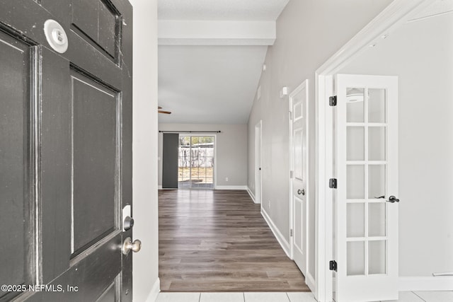 interior space featuring lofted ceiling, wood finished floors, and baseboards