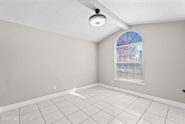 empty room with vaulted ceiling with beams, a textured ceiling, light tile patterned flooring, and baseboards