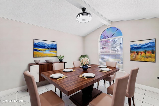 dining room featuring lofted ceiling with beams, light tile patterned floors, baseboards, and a textured ceiling