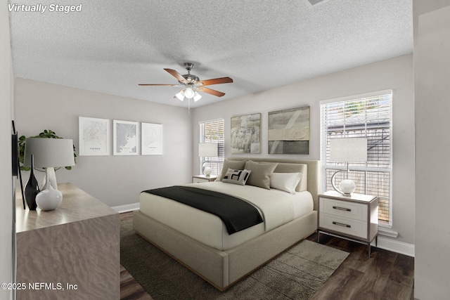 bedroom featuring dark wood-style floors, ceiling fan, a textured ceiling, and baseboards