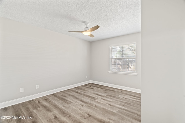 empty room featuring ceiling fan, a textured ceiling, baseboards, and wood finished floors