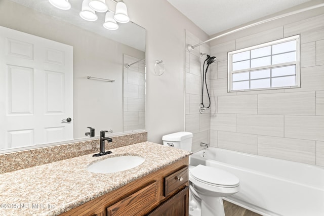 bathroom featuring toilet, tub / shower combination, and vanity