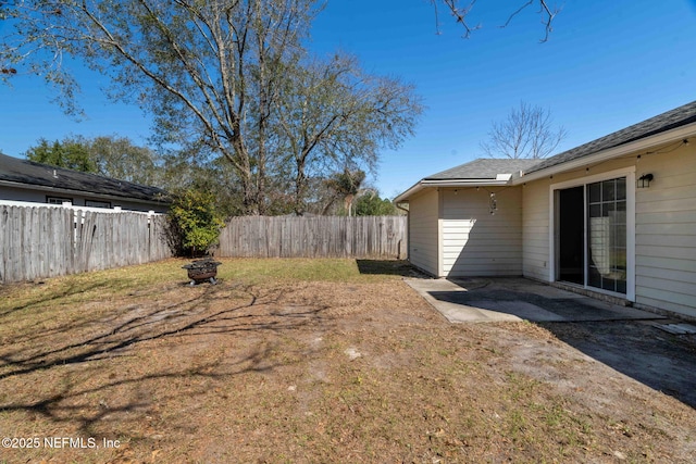 view of yard featuring an outdoor fire pit and fence