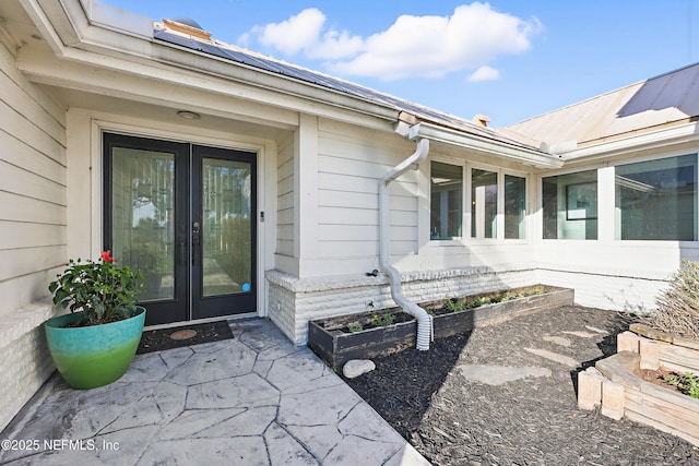 doorway to property featuring metal roof, french doors, and a patio area