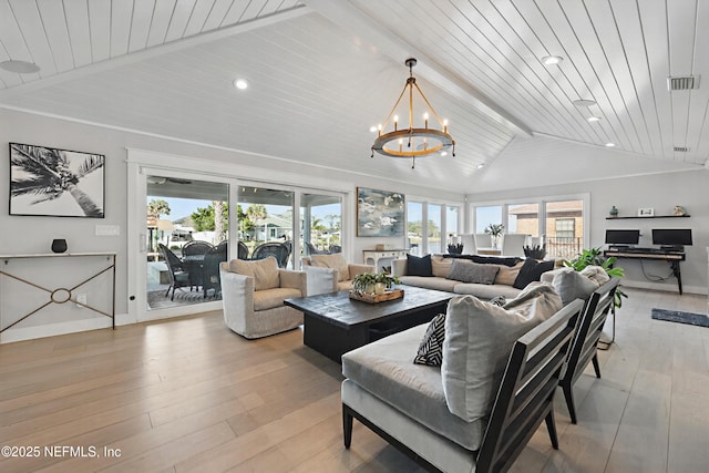 living room featuring vaulted ceiling with beams, plenty of natural light, a chandelier, and visible vents