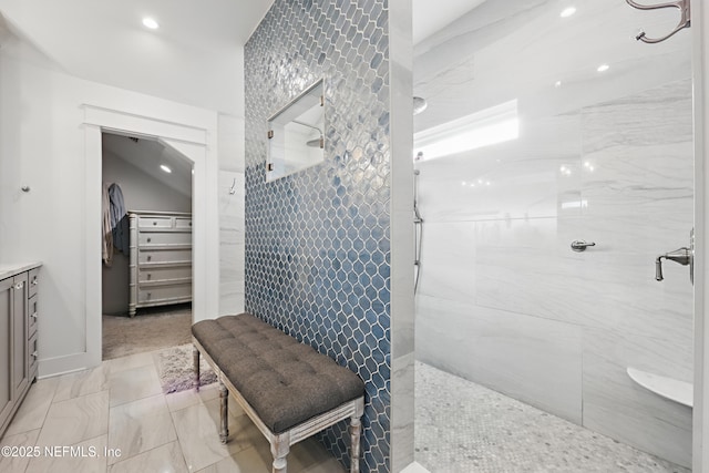 bathroom featuring a walk in closet, walk in shower, and vanity