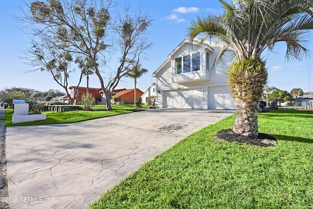 view of front facade with an attached garage, driveway, a front yard, and a residential view