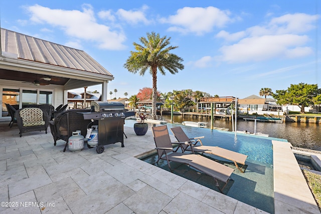 view of patio / terrace featuring grilling area, a water view, and a ceiling fan