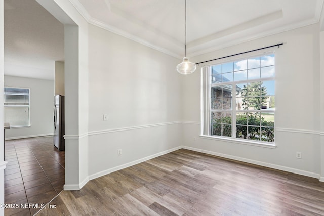 unfurnished room featuring baseboards, a raised ceiling, dark wood-style flooring, and ornamental molding