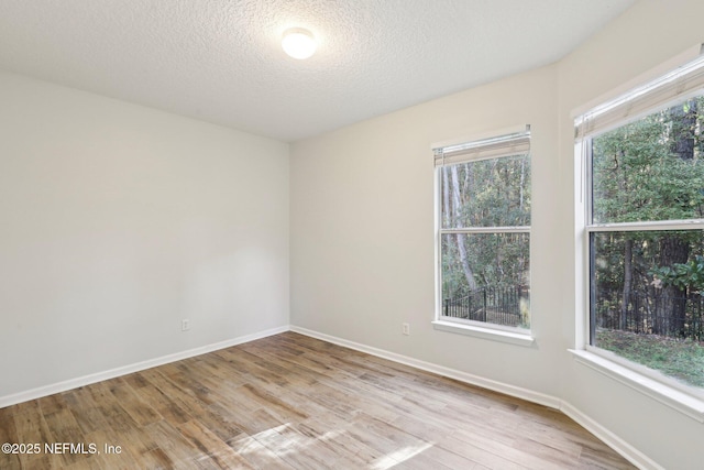 unfurnished room with a wealth of natural light, baseboards, and light wood finished floors