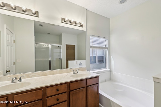 full bath featuring double vanity, a sink, a shower stall, and a bath