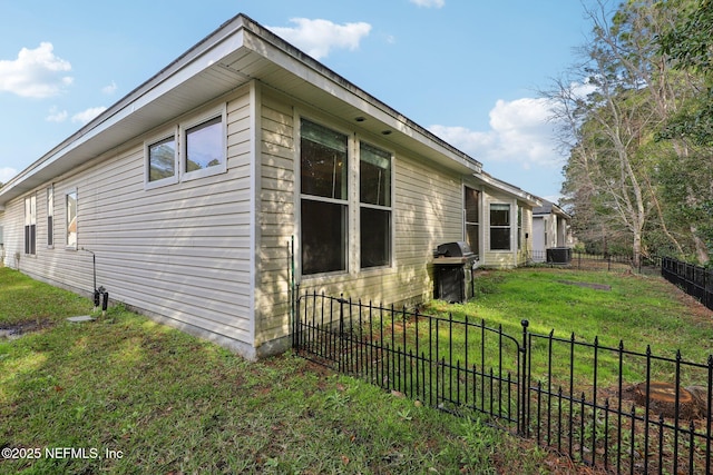 view of side of home with a yard, central AC, and fence private yard