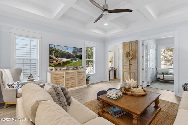 living area with beamed ceiling, a wealth of natural light, and light wood-style floors