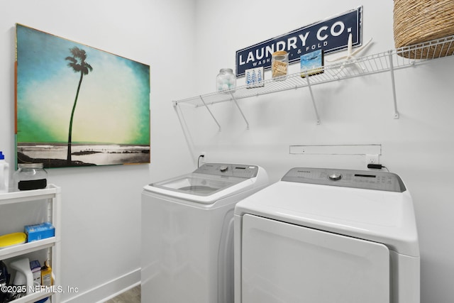 clothes washing area featuring washing machine and dryer, laundry area, and baseboards