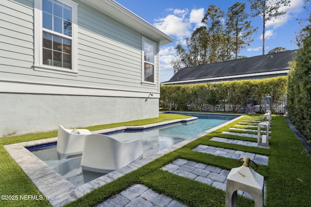 outdoor pool featuring fence and a lawn