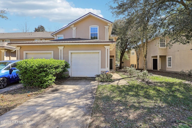 traditional-style home featuring driveway and stucco siding