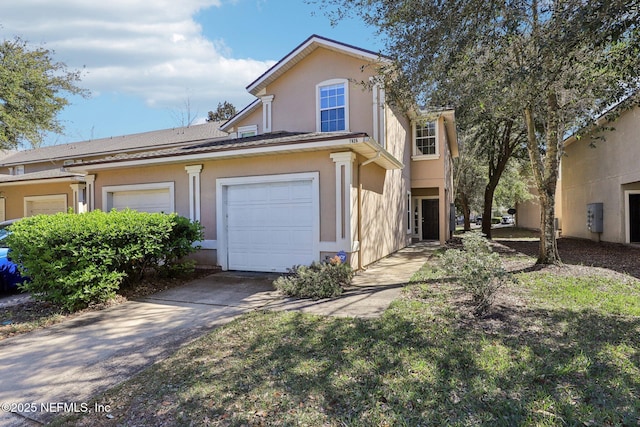 view of front of property with a garage, concrete driveway, and stucco siding