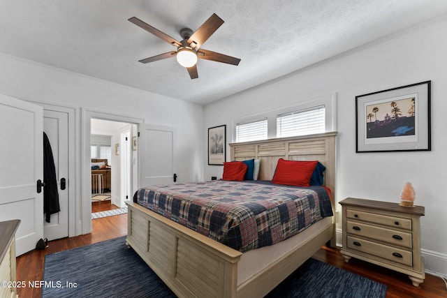 bedroom featuring dark wood-type flooring, ceiling fan, and a textured ceiling