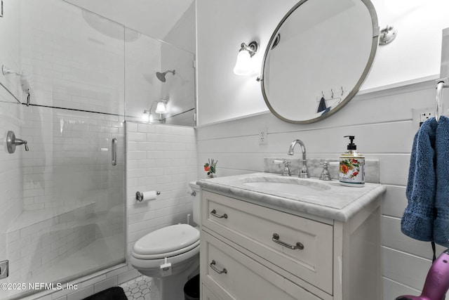 full bathroom with toilet, a stall shower, wainscoting, and vanity