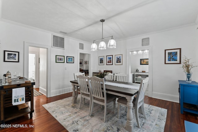 dining area featuring dark wood-type flooring, visible vents, and ornamental molding