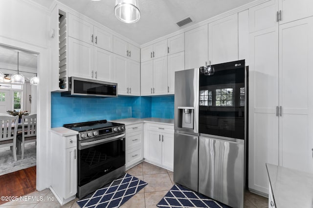 kitchen with white cabinetry, stainless steel appliances, and light countertops