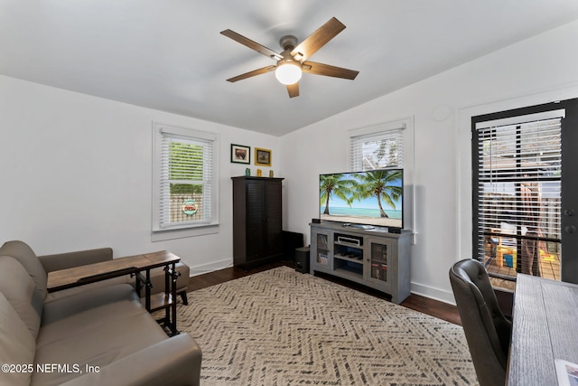 living room with lofted ceiling, dark wood-style flooring, a ceiling fan, and baseboards