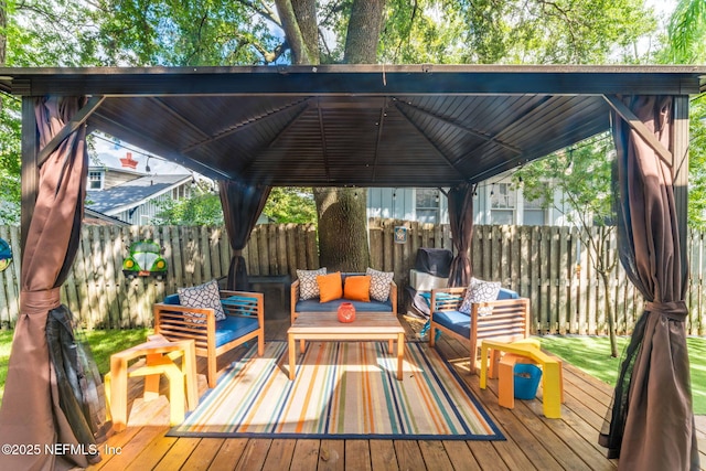 deck featuring a gazebo, fence, and an outdoor living space