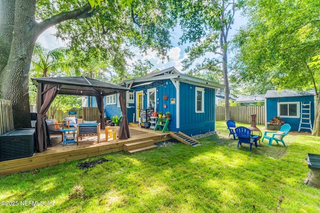 back of property with a gazebo, fence, a shed, an outdoor structure, and a wooden deck