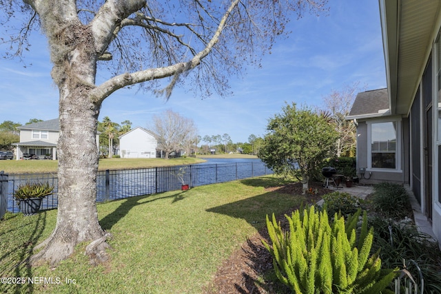 view of yard with a water view and a fenced backyard