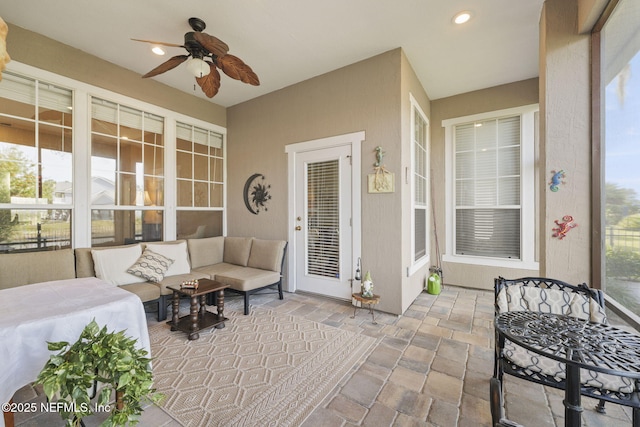 sunroom / solarium featuring a ceiling fan