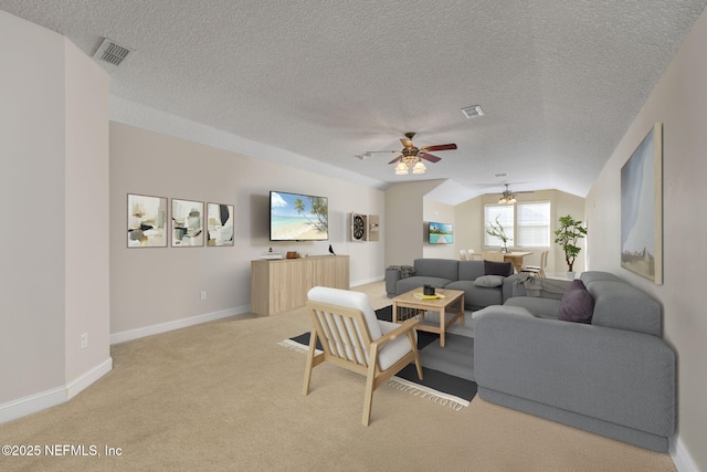 living room featuring visible vents, baseboards, carpet flooring, and vaulted ceiling