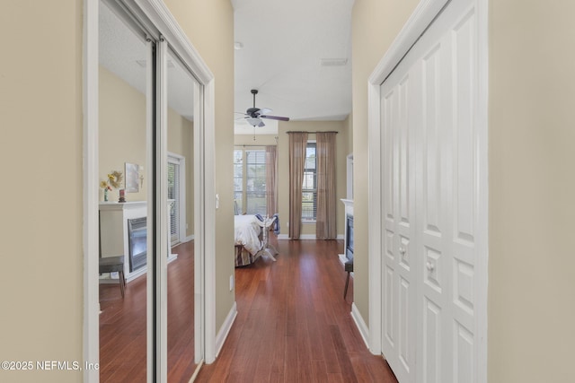 hall featuring dark wood finished floors and baseboards