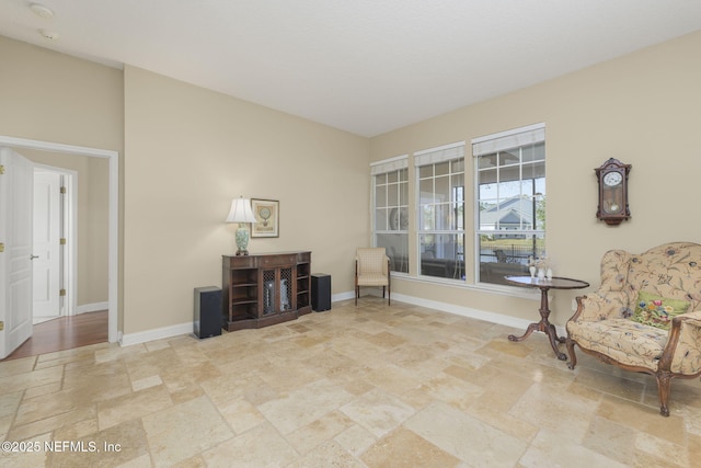 living area with baseboards and stone finish floor