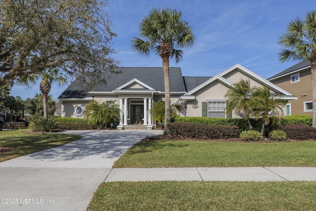 view of front of house with stucco siding and a front yard