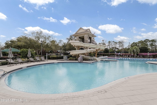 pool with a water slide and a patio area