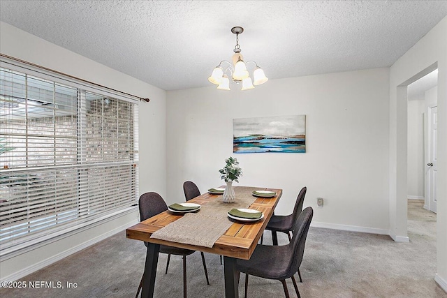 dining room featuring baseboards, a chandelier, a textured ceiling, and light colored carpet