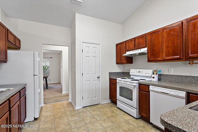 kitchen with under cabinet range hood, white appliances, visible vents, baseboards, and dark countertops