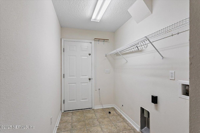 washroom featuring a textured ceiling, laundry area, hookup for a washing machine, and baseboards