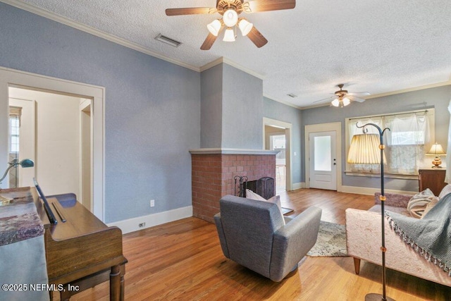 living room with a fireplace, visible vents, and wood finished floors