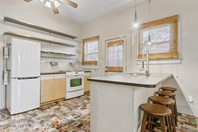 kitchen with decorative light fixtures, crown molding, a breakfast bar area, white appliances, and a peninsula