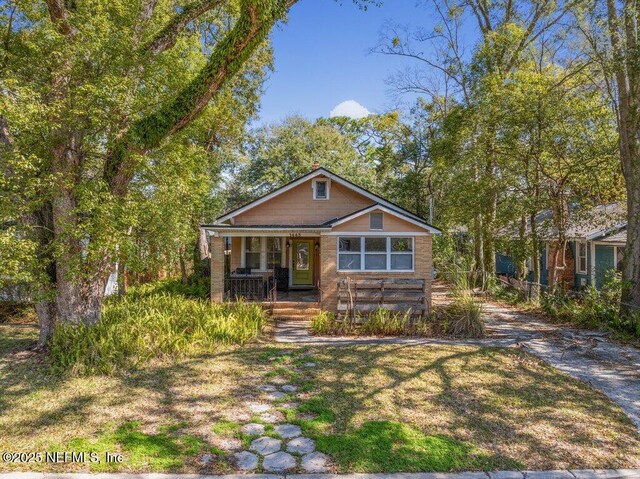 bungalow-style house featuring a porch and a front yard