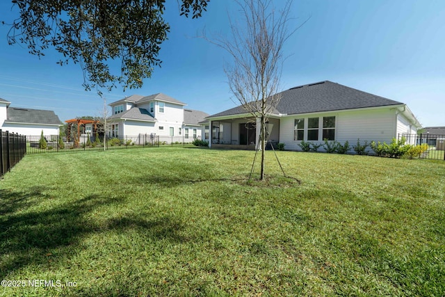 back of property with a fenced backyard and a yard