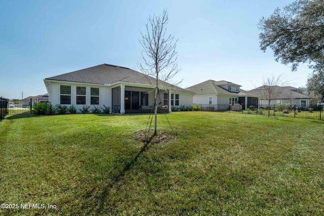 back of property featuring a sunroom, a fenced backyard, and a lawn