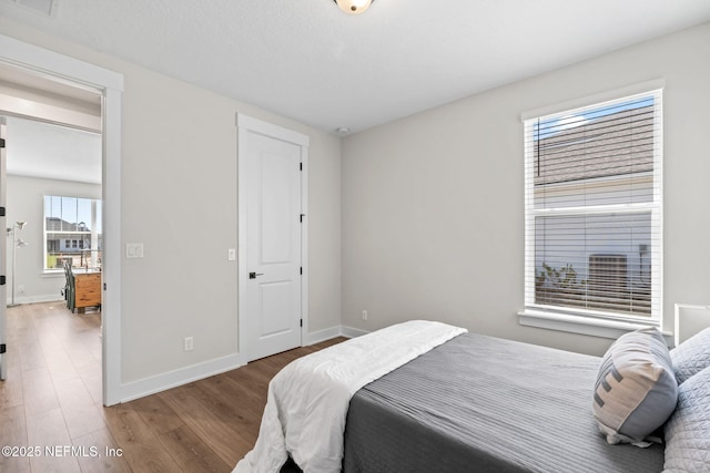 bedroom featuring baseboards and wood finished floors