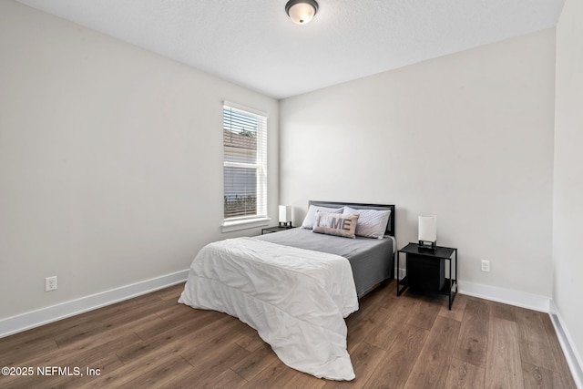 bedroom with baseboards and wood finished floors