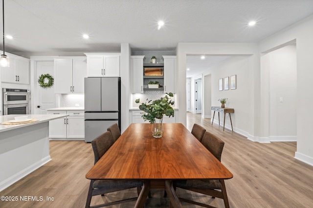 dining area featuring light wood-type flooring, baseboards, and recessed lighting